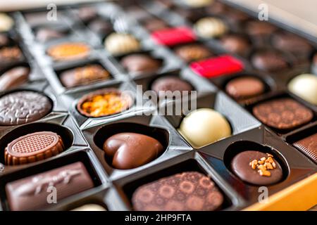 Boîte de chocolats truffes de luxe lait gourmet et desserts sombres avec différentes formes de coeur variété macro gros plan Banque D'Images