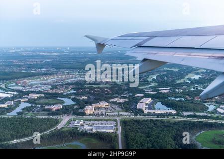 Avion en vol décollage avec fenêtre point de vue aérien de fort Myers, Floride, États-Unis maisons de ville et bâtiments dans le lever du soleil matin Banque D'Images