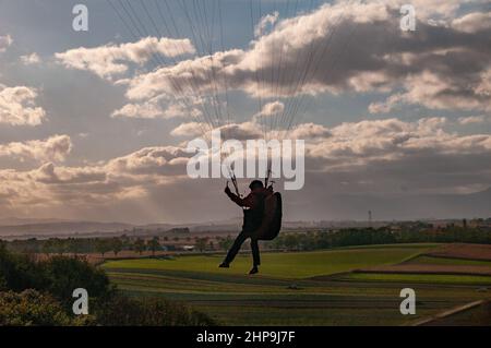 Belle photo d'une silhouette de parapente survolant le terrain Banque D'Images