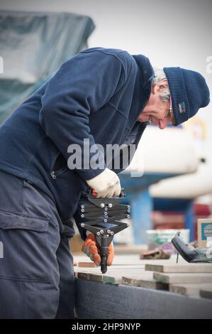 homme plus âgé utilisant un pistolet à rivets pop à ciseaux industriels Banque D'Images