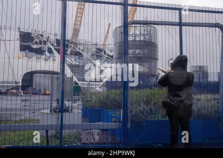 LONDRES, LE 19 2022 FÉVRIER, Un piéton prend une photo alors que l'arène de Londres O2 reste fermée après que le toit ait été ouvert pendant la tempête Eunice le met Office a émis deux avertissements rouges rares alors que le Royaume-Uni a été frappé par la pluie, neige et vents record de 122 km/h pendant la pire tempête depuis 30 ans. Banque D'Images