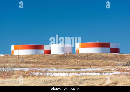 Grands réservoirs de carburant peints en rouge et blanc le jour du soleil Banque D'Images