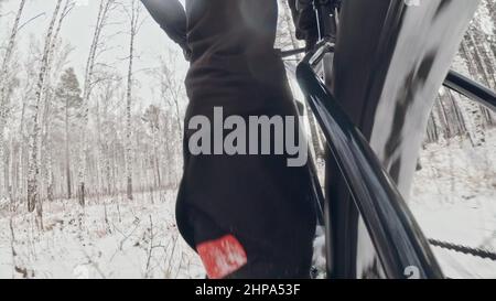 Came d'action sur le châssis installée derrière.Vue en gros plan pov.Cycliste professionnel de sport extrême à vélo gros en plein air dans la forêt enneigée d'hiver. Banque D'Images