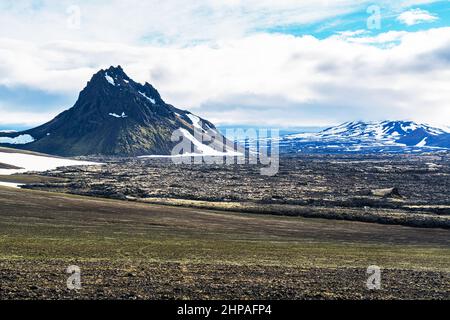 Magnifique paysage volcanique avec montagne enneigée et rochers de lave rugueux dans les hautes terres en été, Islande. Banque D'Images