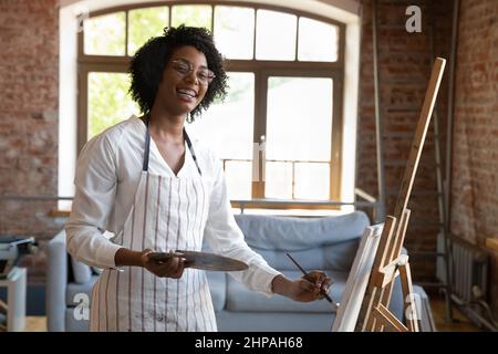 Portrait de la jeune femme afro-américaine créative qui dessine en studio. Banque D'Images