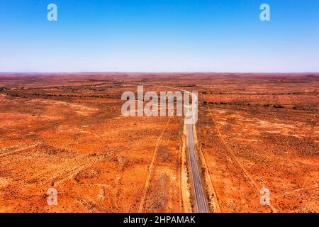 Autoroute sinueuse et isolée en terre rouge dans l'arrière-pays de l'Australie, de Broken Hill à Adélaïde. Banque D'Images