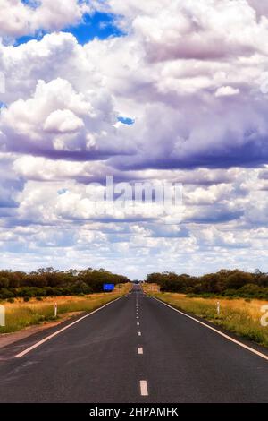 Autoroute sans fin et sans fin de Broken Hill dans l'Outback australien - paysage vertical nuageux. Banque D'Images