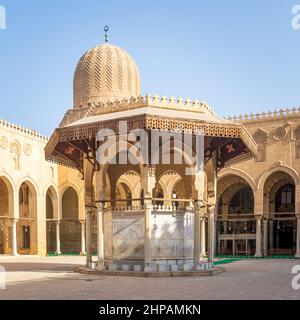 Fontaine d'ablution servant de support à la cour de la mosquée historique publique du Sultan al Muayyad, avec arrière-plan de couloirs voûtés entourant la cour, et dôme de la mosquée, le Caire, Egypte Banque D'Images