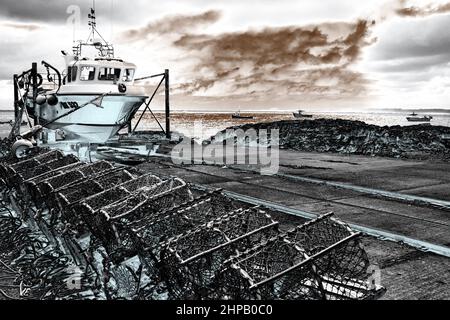 Pots de homard et bateau de pêche, Lindisfarne, Northumberland, Royaume-Uni Banque D'Images