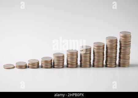 Piles de pièces d'argent dans l'ordre croissant sur fond gris clair Banque D'Images