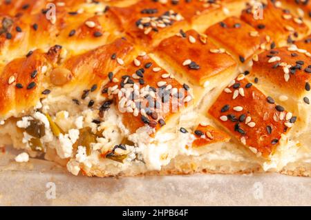 tarte salée de pâte feuilletée parsemée de sésame sur fond de bois Banque D'Images