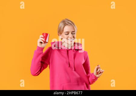 Femme avec enceinte portable sans fil, qui écoute de la musique et danse sur fond de couleur Banque D'Images