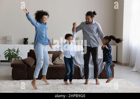 Une famille afro-américaine accueillante qui sauva dans un salon moderne. Banque D'Images