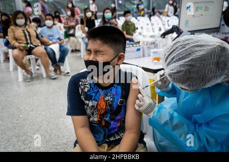 Bangkok, Thaïlande. 20th févr. 2022. Un jeune garçon reçoit le vaccin Pfizer-BioNTech COVID-19 les enfants âgés de 5-11 à 64 ans reçoivent le vaccin Pfizer-BioNTech COVID-19 (Comirnaty) à la gare centrale de Bang Sue à Bangkok. Crédit : SOPA Images Limited/Alamy Live News Banque D'Images