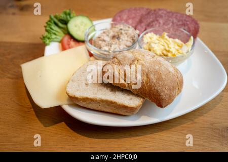 Assiette de petit-déjeuner allemande avec pain croustillant, fromage, saucisse et tartinades crémeuses sur une table en bois, concentration sélectionnée, champ étroit Banque D'Images