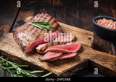 Griller du Wagyu Flank Steak sur une planche à découper. Arrière-plan en bois. Vue de dessus Griller du Wagyu Flank Steak sur une planche à découper. Arrière-plan en bois. Vue de dessus