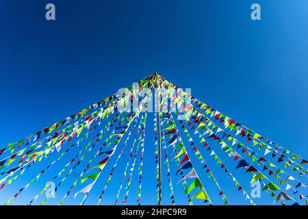 Guirlande de drapeaux triangulaires multicolores sur fond bleu ciel. Décoration de fête. Copier l'espace Banque D'Images