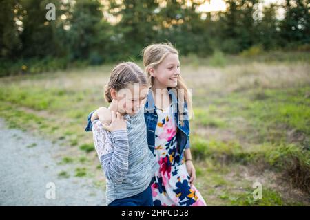 Deux jeunes filles rient, sourient, jouent à l'extérieur. Banque D'Images