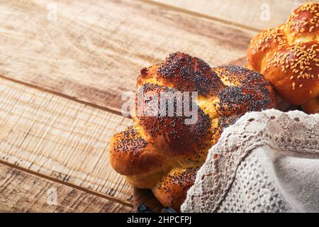 Shebbat Shalom. Gallah de pain aux graines de sésame et de pavot sur fond de bois. Pain juif traditionnel pour Shabbat et vacances. Décoration rustique Banque D'Images