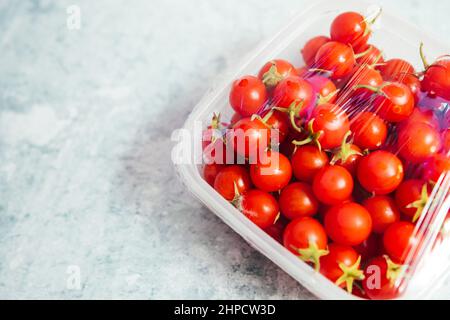 Utilisation d'un film d'emballage alimentaire pour le stockage des tomates cerises naturelles et biologiques dans le réfrigérateur. Vue de dessus Banque D'Images