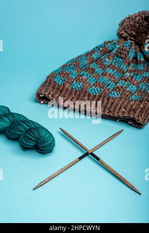 Chapeau d'hiver bleu et marron avec motif à carreaux sur fond bleu. Banque D'Images