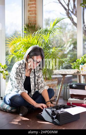 Femme adulte tapant sur la terrasse de sa maison. Le temps de l'inspiration et de la créativité. Espace pour le texte. Banque D'Images