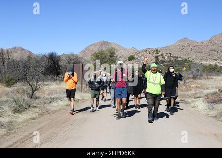 Les 24 coureurs relais et les membres de la tribu Apache de San Carlos chantent “Save Oak Flat” tout en marchant le dernier quart de mille de la course de 13 miles transportant le bâton avec les plumes sacrées au terrain de camping Oak Flat à Miami, Arizona, États-Unis le 19 février 2022. Inscrite au Registre national des lieux historiques, cette parcelle de terre connue sous le nom de Oak Flat a été considérée comme un lieu sacré par l'Apache pendant des milliers d'années où ils vont là pour prier, tenir des cérémonies, et considéré comme la maison des êtres spirituels. Depuis que l'un des plus grands gisements de cuivre au monde a été découvert 7 000 pieds en dessous Banque D'Images