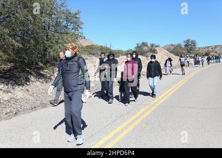 Les 24 relais coureurs et les membres de la San Carlos Apache Tribe marche la finale ? Mille de la course de 13 miles transportant le bâton avec les plumes sacrées jusqu'au terrain de camping Oak Flat à Miami, Arizona, États-Unis, le 19 février 2022. Inscrite au Registre national des lieux historiques, cette parcelle de terre connue sous le nom de Oak Flat a été considérée comme un lieu sacré par l'Apache pendant des milliers d'années où ils vont là pour prier, tenir des cérémonies, et considéré comme la maison des êtres spirituels. Depuis que l'un des plus grands gisements de cuivre au monde a été découvert à 7 000 pieds au-dessous de Oak Flat, une bataille a fait rage p Banque D'Images