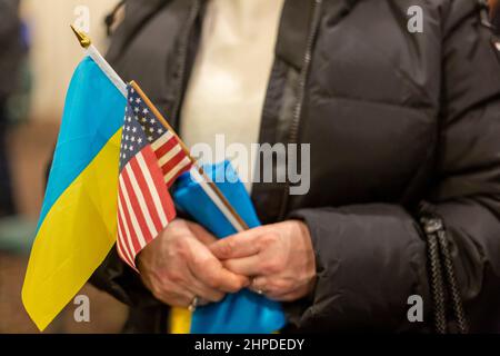 Warren, Michigan, États-Unis. 20th févr. 2022. Le Comité de réponse de crise américano-ukrainien organise un rassemblement « avec l'Ukraine » tandis que les résidents craignent les conséquences d'une possible invasion russe dans ce pays. Près de 40 000 résidents du Michigan sont d'origine ukranienne.Une femme aide les drapeaux ukrainiens et américains. Crédit : Jim West/Alay Live News Banque D'Images