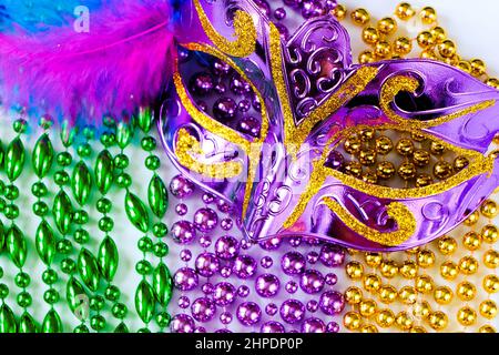 Masque de carnaval violet avec plumes et perles colorées gros plan. Symbole Mardi gras gras ou Mardi gras. Décorations de fête pour des vacances traditionnelles. Banque D'Images