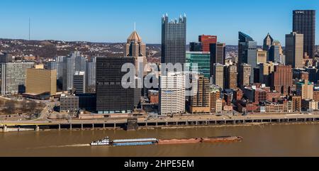 Un remorqueur poussant quatre barges sur une rivière Monongahela boueuse à côté du centre-ville de Pittsburgh, Pennsylvanie, États-Unis Banque D'Images
