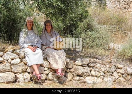 Les actrices qui représentent les femmes du premier siècle se trouvent à l'ombre au musée en plein air du village de Nazareth, en Israël. Banque D'Images