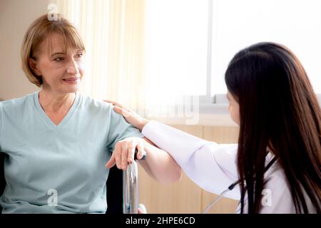 Médecin femme encourager et prendre soin patient senior assis en fauteuil roulant à l'hôpital, médecin amical avec les personnes âgées, maladie diagnostique et illnes Banque D'Images