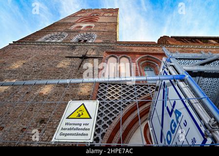 15 février 2022, Brandebourg, Francfort (Oder) : un panneau indiquant « Avertissement de chute d'objets » est affiché sur une clôture de construction en face de l'église Sainte-Marie dans le centre-ville de la ville frontalière germano-polonaise. L'imposante Marienkirche est la plus grande église médiévale de Brandebourg et un point de repère de Francfort. Ce n'est qu'après la chute du mur de Berlin que les ruines ont été restaurées dans un bâtiment sacré presque complet avec le Trésor spécial d'une Bible en verre. Mais le monument reste un cas de réaménagement. (À dpa: 'Quand le monument médiéval s'effondre') photo: Patrick Pleul/dpa-Zent Banque D'Images