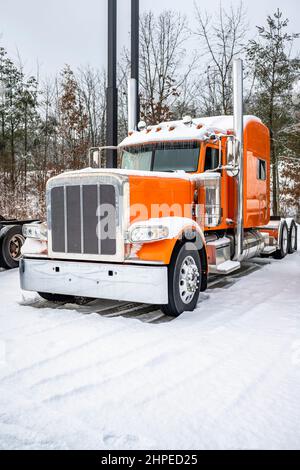 Tracteur semi-remorque classique orange long-courrier professionnel avec cabine allongée, debout sans semi-remorque, pour le conducteur de camion, repose sur l'hiver Banque D'Images