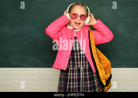 Adolescente fille d'école avec sac à dos sur tableau noir. Portrait d'une adolescente étudiante. Fille d'école drôle portant des lunettes. Jeune adolescent Banque D'Images