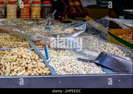 De nombreux types différents de noix et de graines grillées à vendre sur le marché. Gros plan. Banque D'Images