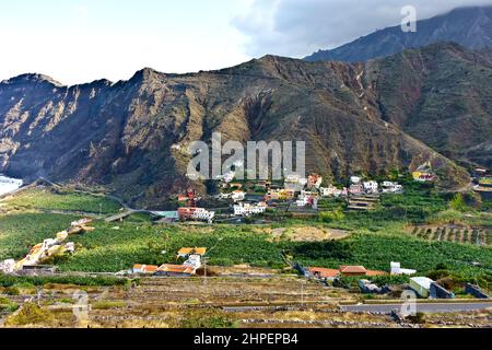 Village d'Hermigua, la Gomera, îles Canaries: Maisons colorées sur une pente de montagne et bananier dans la vallée, en hiver. Banque D'Images