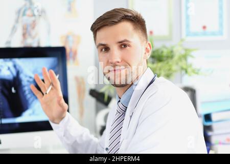 Haut point de spécialiste sur le moniteur avec l'acquisition, homme intelligent médecin porter l'uniforme médical blanc Banque D'Images