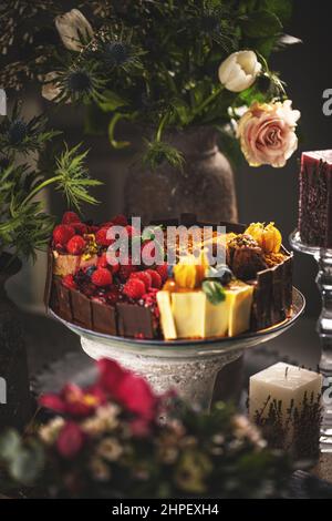 Différentes tranches de divers gâteaux, faisant une seule torte entière sur le support à gâteau, encore la vie Banque D'Images