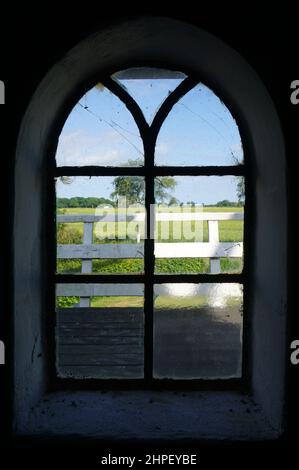 La vue d'une fenêtre d'une ancienne usine. Il a une arche et des panneaux de verre. Banque D'Images