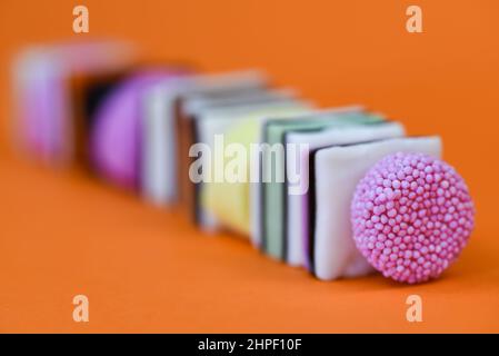 Den Helder, pays-Bas. Janvier 2022. Divers types de réglisse anglaise de différentes couleurs sur fond orange. Photo de haute qualité Banque D'Images