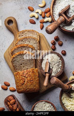 Cuisson du pain au keto. Différents types de farine de noix - amande, noisette, noix de cajou et ingrédients de boulangerie, fond sombre, vue de dessus. Concept sans gluten. Banque D'Images