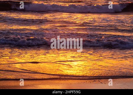 L'océan Pacifique se déforme sur une plage de sable au coucher du soleil à Mazatlan, au Mexique. Banque D'Images