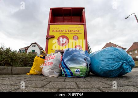 Bannewitz, Allemagne. 21st févr. 2022. Plusieurs sacs et un sac bleu avec des vêtements emballés se trouvent devant un conteneur de collecte dans une épicerie à prix réduit à Bannewitz, Saxe. Les vêtements sont recueillis dans ces endroits centraux et traités avec l'aide de partenaires commerciaux ou à but non lucratif. Credit: Daniel Schäfer/dpa-Zentralbild/dpa/Alay Live News Banque D'Images