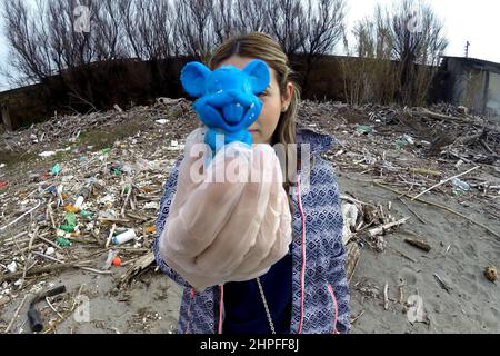 Castel Volturno, Italie. 20th févr. 2022. Volontaire de l'association Plastic Free avec un ours en peluche trouvé sur la plage dans ses mains, pendant qu'elle nettoyait la 'Plastic Beach' de Castel Volturno, ainsi appelé pour l'énorme quantité de déchets accumulés apporté par l'inondation de la rivière Volturno. Castel Volturo, Italie, 20 février 2022. Credit: SIPA USA/Alay Live News Banque D'Images