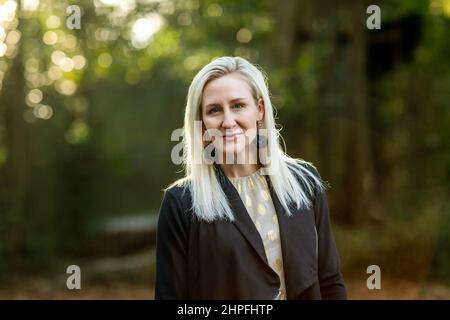 Une belle femme blonde de buisness dans ses années trente dehors dans un fond naturel avec l'espace de copie Banque D'Images