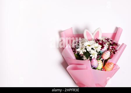 Bouquet de fleurs de Pâques et œufs colorés sur fond blanc. Copier l'espace Banque D'Images