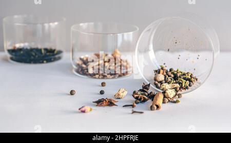 Différents types de thé dans des pots en verre sur un fond clair, isolé. Banque D'Images