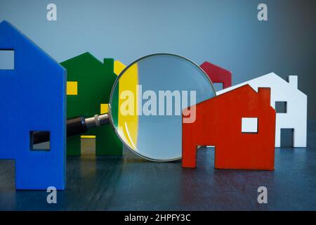 Inspection de la maison ou concept de sélection. Bâtiments colorés et une loupe. Banque D'Images